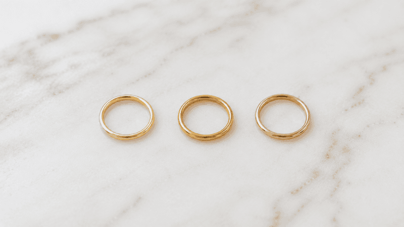 color comparison of 14k and 18k yellow gold rings on white marble