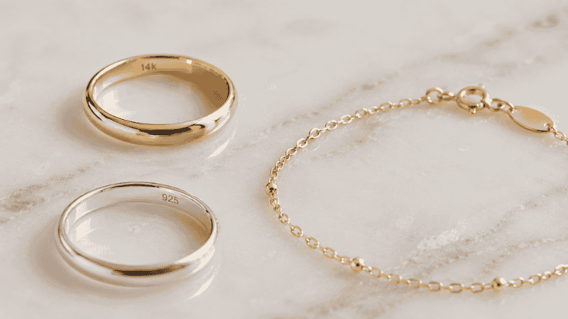 jewelry materials comparison — 14k solid gold ring, 925 sterling silver ring, and gold vermeil bracelet