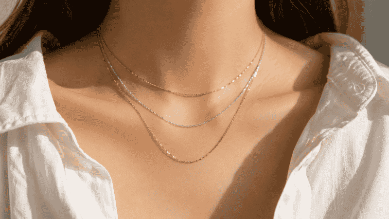 mixing gold and silver necklaces in a layered stack — modern mixed metal jewelry styling
