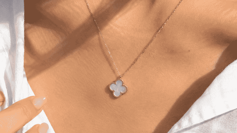 van cleef necklace dupe — delicate four-leaf clover gold pendant with mother-of-pearl on collarbone