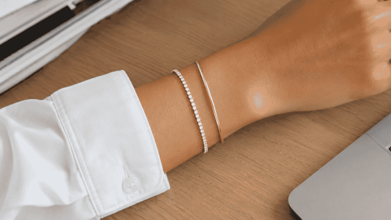 everyday office bracelet stack — slim tennis bracelet and thin gold bangle on wrist with white shirt cuff