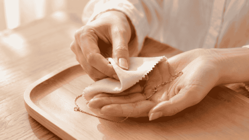 caring for gold vermeil jewelry — wiping necklace with soft microfiber cloth to extend plating life