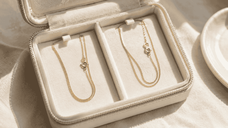 storing necklaces separately with clasps fastened to prevent tangling — organized jewelry box with two gold chains