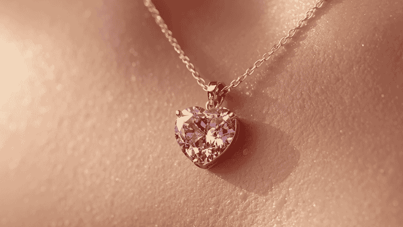 A high-definition macro shot of the Kendra Scott Ari Heart necklace in Pink Drusy, highlighting the shimmering crystal texture and the delicate gold-plated setting.