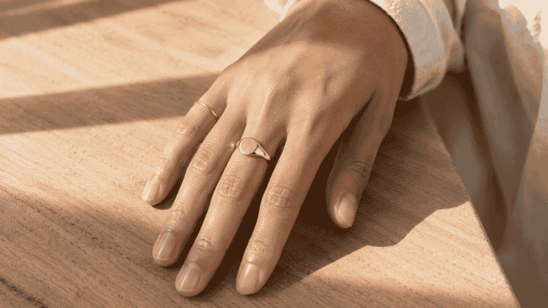 wearing rings on multiple fingers — balanced ring styling with gold rings on index middle and pinky leaving ring finger bare